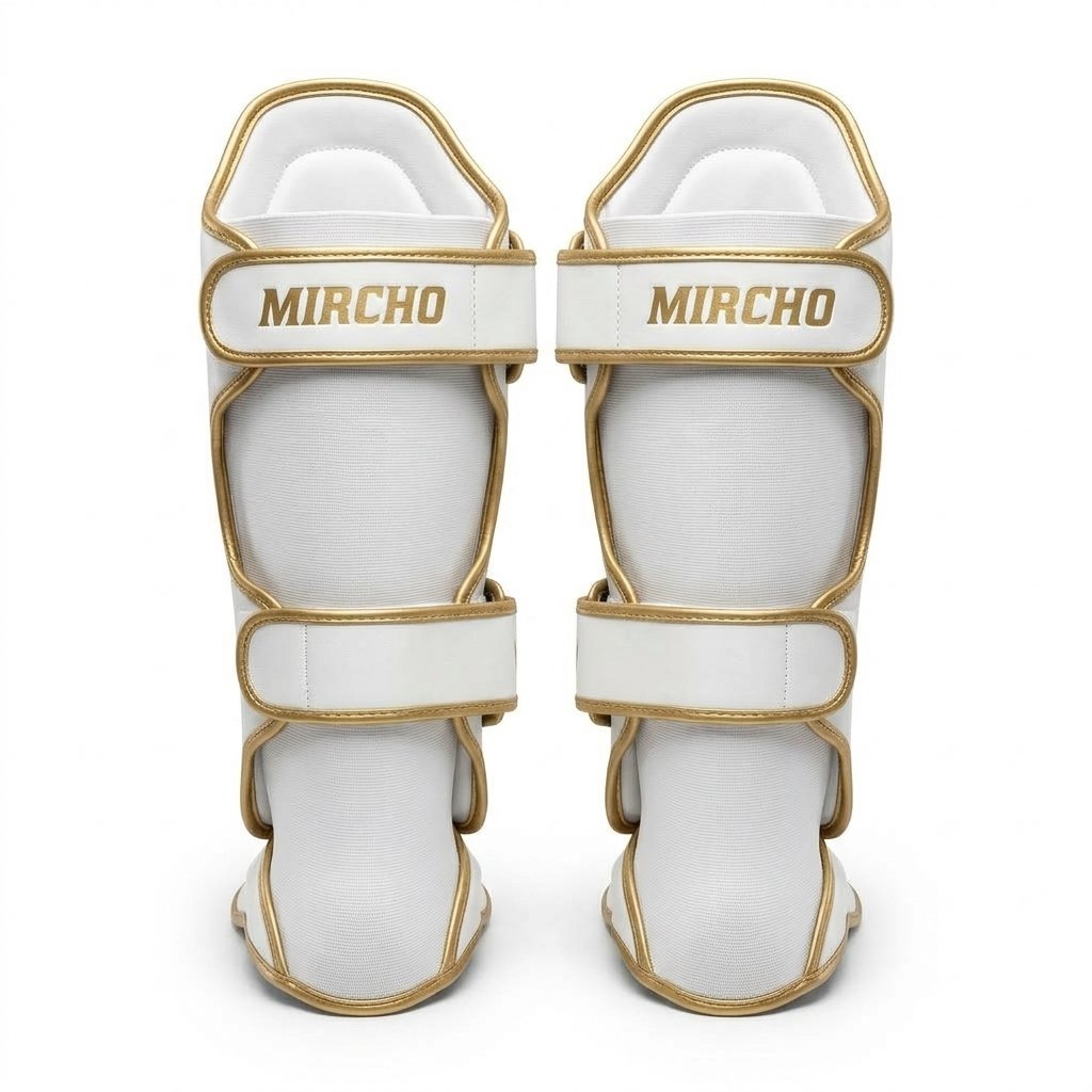 Pair of white and gold MMA shin guards with secure straps and integrated foot padding. - alternate view 3