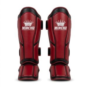 Red and black MMA shin guards with padding and dual straps.