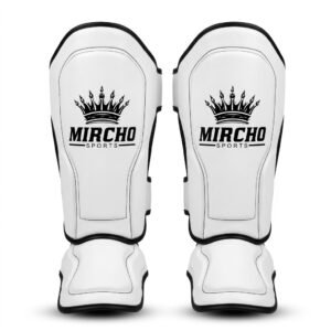 Pair of white martial arts shin guards featuring integrated instep padding and black strap closures.